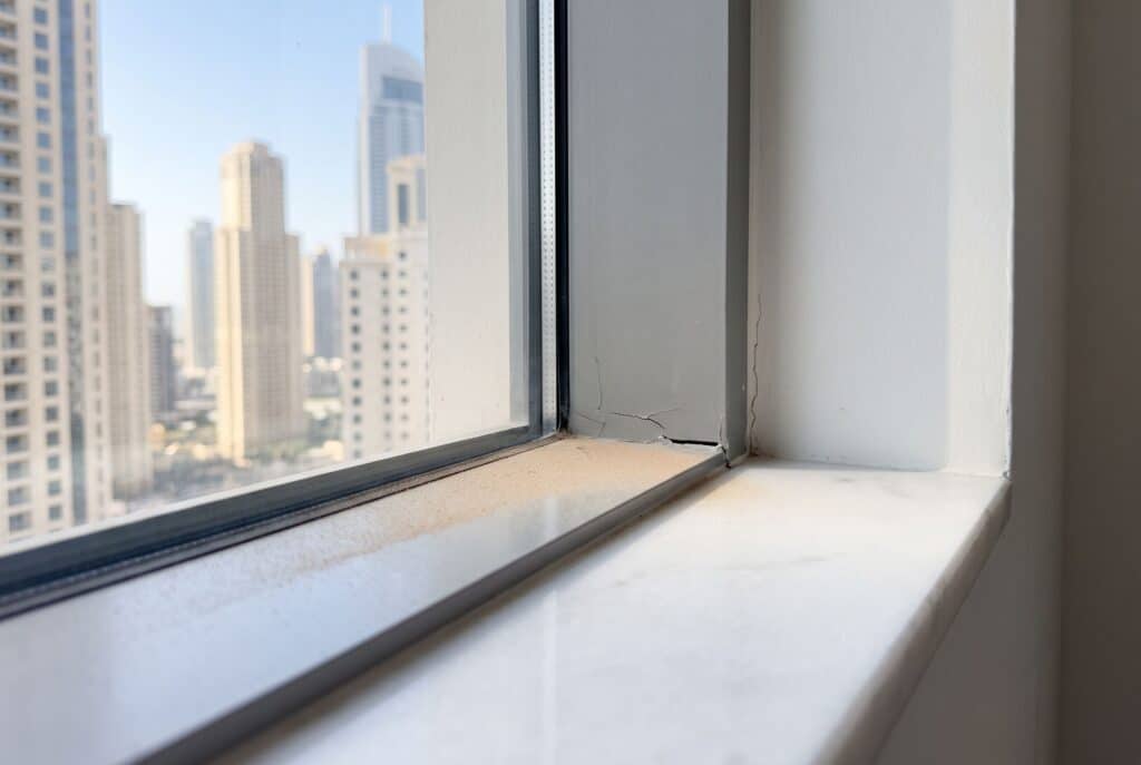 Fine dust on a windowsill in a Dubai apartment caused by worn how to reseal window seals