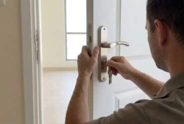 BHMS Home Maintenance| Handyman replacing a door lock cylinder on a white apartment door in Dubai using a screwdriver