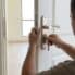 BHMS Home Maintenance| Handyman replacing a door lock cylinder on a white apartment door in Dubai using a screwdriver