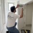 BHMS handyman installing a low profile door stopper on the floor in a Dubai apartment