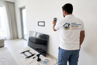 Handyman checking for wall studs before mounting a TV on a gypsum wall in a Dubai apartment