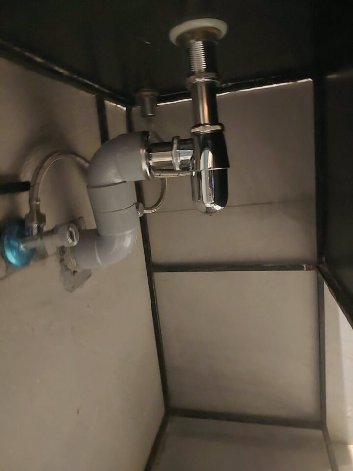 New chrome bottle trap under the basin